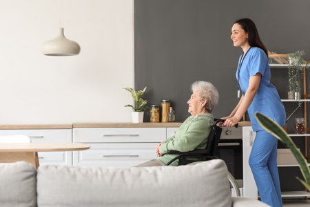Young caregiver with senior woman in wheelchair at homeの写真素材