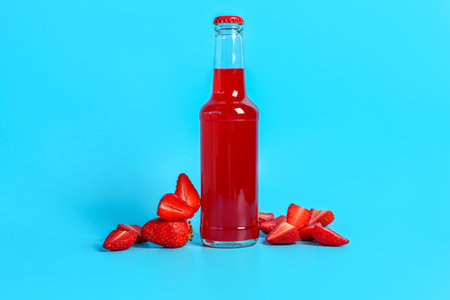 Bottle of fresh soda and strawberry on blue backgroundの写真素材