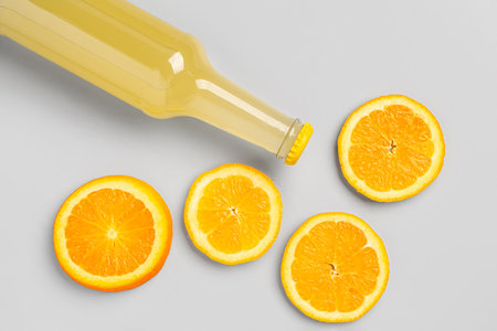 Composition with bottle of fresh soda and orange on gray backgroundの写真素材