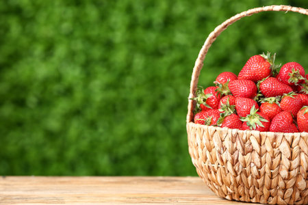 Basket with fresh strawberry on wooden table outdoorsの写真素材
