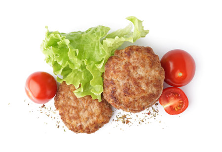 Tasty meat cutlets with fresh tomatoes and lettuce on white backgroundの写真素材