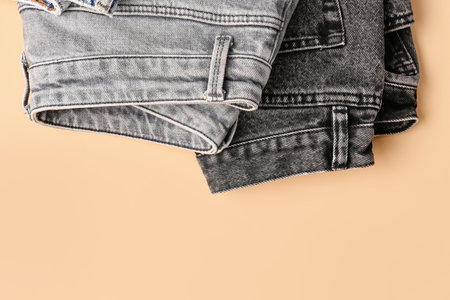 Different stylish folded jeans on pale orange backgroundの写真素材