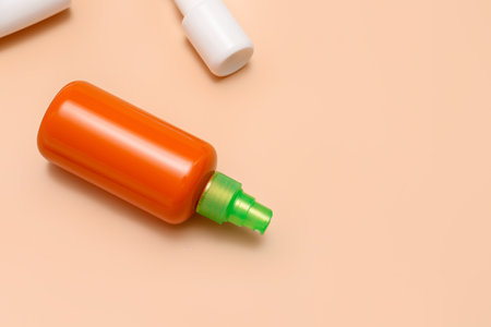 Different bottles of sunscreen cream on pale orange backgroundの写真素材