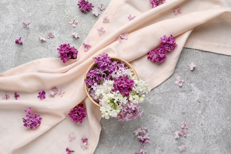 Wooden bowl of beautiful fragrant lilac flowers on grunge gray backgroundの写真素材
