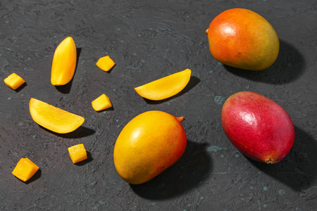fresh ripe mangoes on black backgroundの写真素材