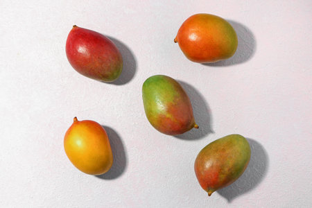 fresh ripe mangoes on light backgroundの写真素材