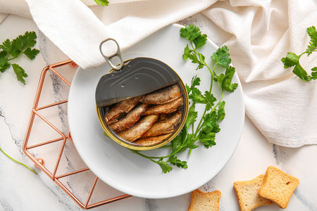 Plate of canned smoked sprats with parsley on white tableの写真素材