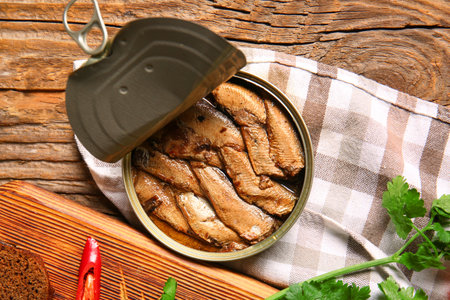 Canned smoked sprats with parsley on wooden tableの写真素材