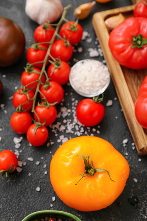 Different fresh tomatoes on black backgroundの写真素材