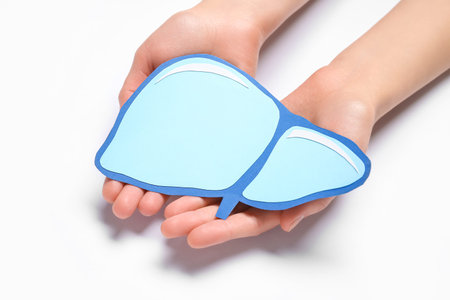 Female hands holding blue paper liver on white backgroundの写真素材