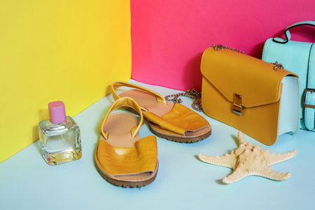 Sandals with perfume and bags near color wallの写真素材