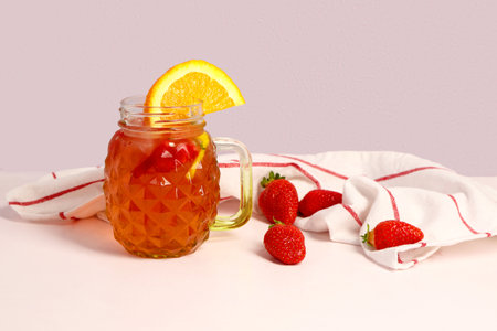 Mason jar of tasty strawberry juice on white tableの写真素材