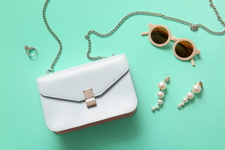 Stylish bag and accessories on turquoise background