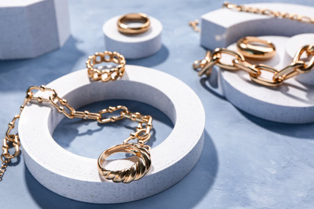 Decorative podiums with beautiful golden jewelery on grunge blue backgroundの写真素材