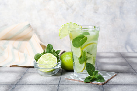 Glass of cold mojito and ingredients on tableの写真素材