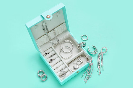 Organizer with stylish jewelry on turquoise background