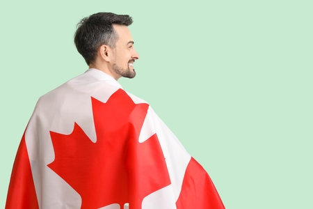 Handsome man with flag of Canada on green backgroundの写真素材