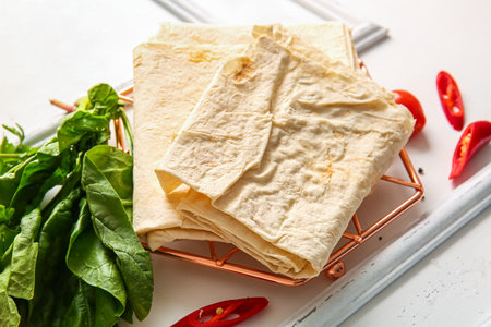 Grid with fresh lavash on white wooden backgroundの写真素材