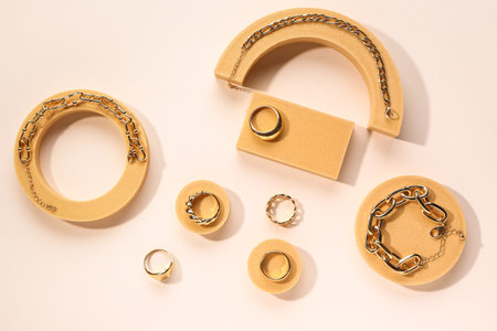 Decorative podiums with rings and bracelets on beige backgroundの写真素材