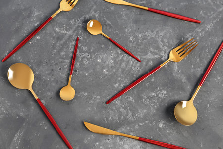 Golden cutlery with red handles on dark backgroundの写真素材