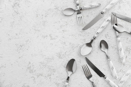 Stainless steel cutlery with plastic handles on white backgroundの写真素材