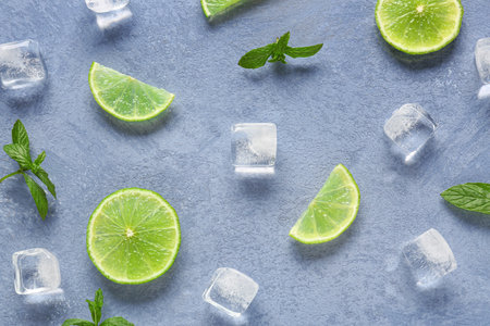 Slices of fresh lime with mint and ice cubes on blue backgroundの写真素材