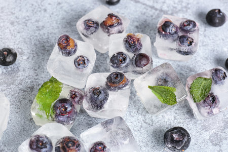 Fresh blueberry frozen in ice cubes on grunge backgroundの写真素材