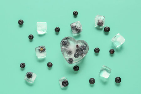 Ripe blueberry frozen in ice and fresh berries on blue backgroundの写真素材