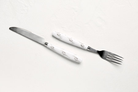 Stainless steel fork and knife with plastic handles on white backgroundの写真素材