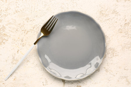 Plate with golden fork on white backgroundの写真素材