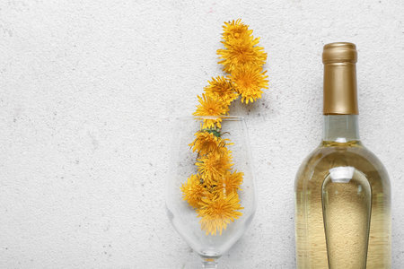 Bottle and glass of dandelion wine on white backgroundの写真素材