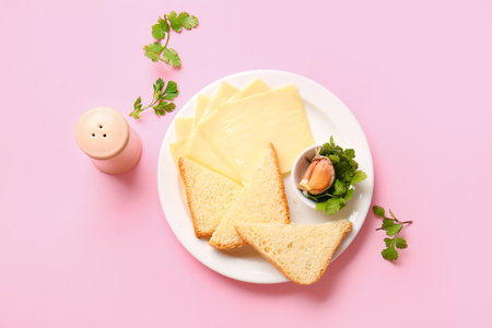 Plate of tasty processed cheese with herbs and garlic on pink backgroundの写真素材