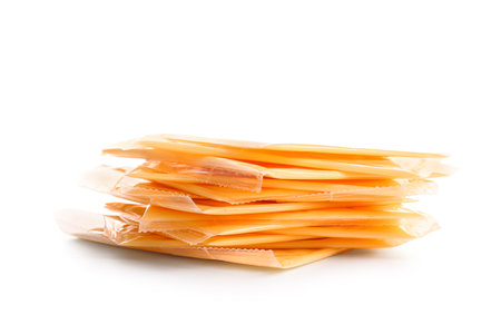Slices of tasty processed cheese on white backgroundの写真素材