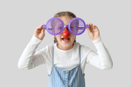 Little girl in funny disguise on light background. Children's Day celebrationの写真素材