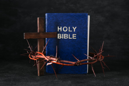 Holy Bible with crown of thorns and cross on black backgroundの写真素材