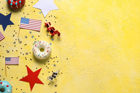 Composition with donuts, USA flags and confetti on yellow table. independence day celebrationの写真素材