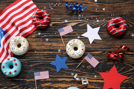 Composition with donuts, USA flags and confetti on wooden table. independence day celebrationの写真素材