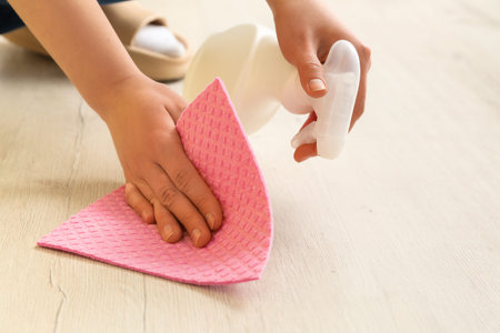 Woman wiping floor at home, closeup