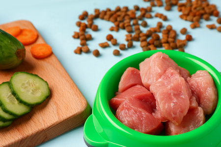 Dry pet food, raw meat and natural products on blue background, closeupの写真素材