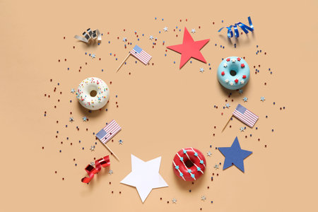 Frame made of donuts, USA flags and confetti on beige background. independence day celebrationの写真素材