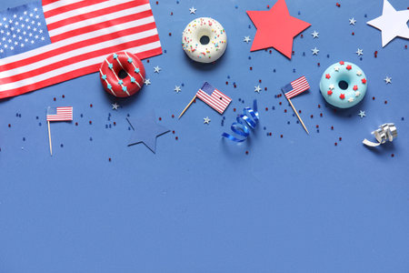 Composition with donuts, USA flags and confetti on blue background. independence day celebrationの写真素材