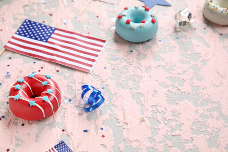 Composition with donuts, USA flag and confetti on pink grunge table. independence day celebrationの写真素材