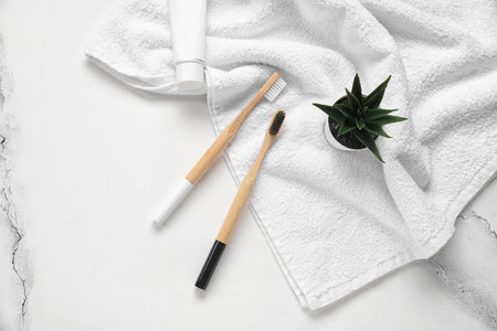 Bamboo toothbrushes with towel on white marble backgroundの写真素材