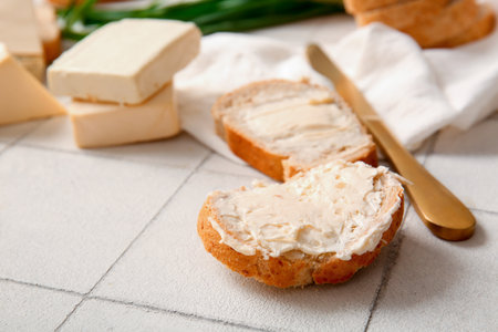 Sandwiches with processed cheese and herbs on white tile backgroundの写真素材