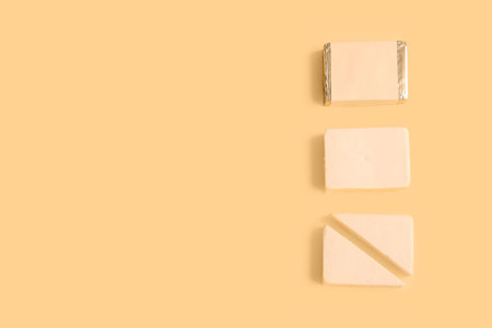 Sliced processed cheese on yellow backgroundの写真素材