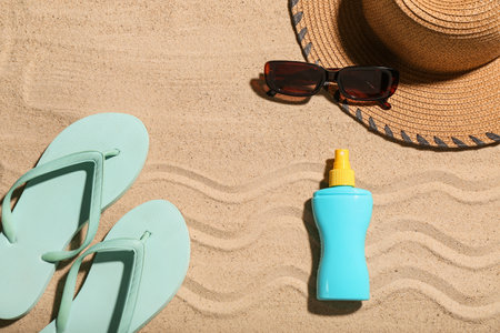 Creative composition with sunscreen cream and beach accessories on sandの写真素材