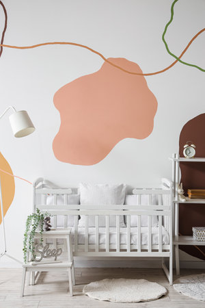 Interior of stylish bedroom with baby crib and shelving unitの写真素材