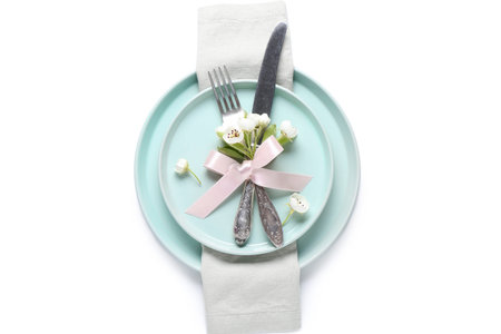 Beautiful table setting with blooming tree branch and cutlery isolated on white background