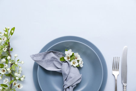 Beautiful table setting with blooming tree branches on gray backgroundの写真素材