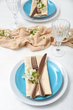 Beautiful table setting with blooming tree branches on white backgroundの写真素材